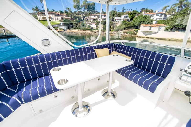 Slide: The Image of Luxurious 2005 Navigator 4400 Pilothouse yacht interior with blue-striped seating and waterfront view. - 14