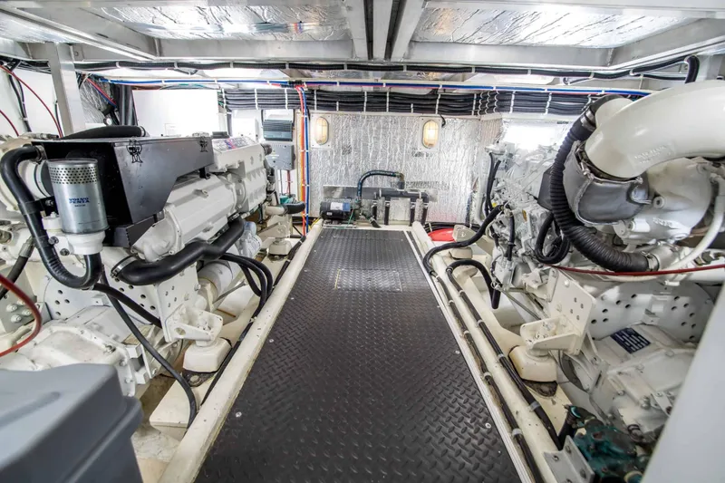 Slide: The Image of Engine room of 2005 Navigator 4400 Pilothouse yacht, featuring dual engines and metallic flooring. - 23
