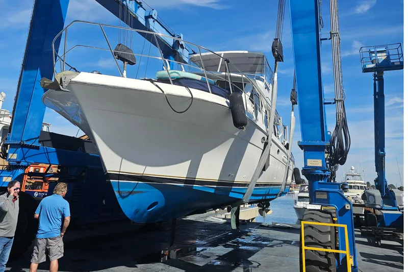 Slide: The Image of 2005 Navigator 4400 Pilothouse yacht lifted by blue crane at marina. - 26