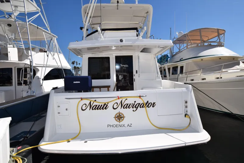 Slide: The Image of 2005 Navigator 4400 Pilothouse yacht interior with covered seating and table, docked at marina. - 34