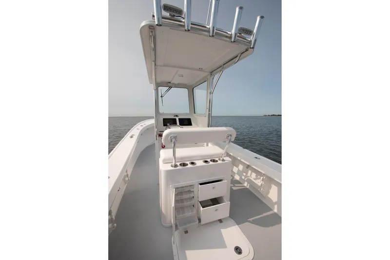 Slide: The Image of 2026 Steiger Craft 23 Chatham boat interior with helm and storage, on calm water. - 5