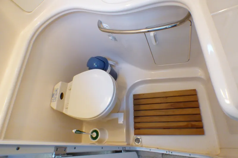 Slide: The Image of Bathroom of 2002 Sea Ray 340 Sundancer with toilet and wooden floor mat. - 12