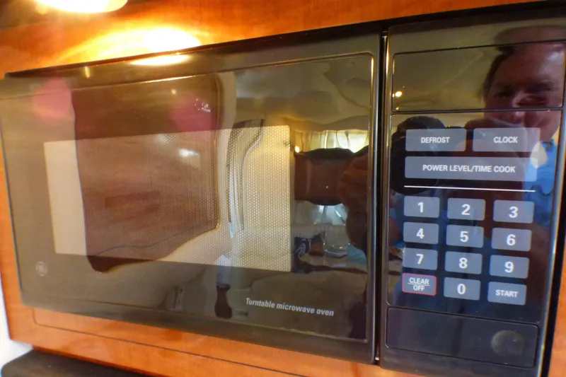 Slide: The Image of Microwave oven inside 2002 Sea Ray 340 Sundancer yacht, featuring digital controls and wood paneling. - 15