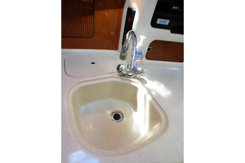 Slide: The Image of 2002 Sea Ray 340 Sundancer kitchen sink with faucet and soap dispenser. - 16