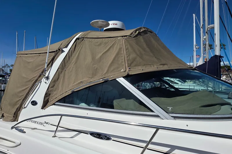 Slide: The Image of 2002 Sea Ray 340 Sundancer boat with tan canvas cover in marina. - 17