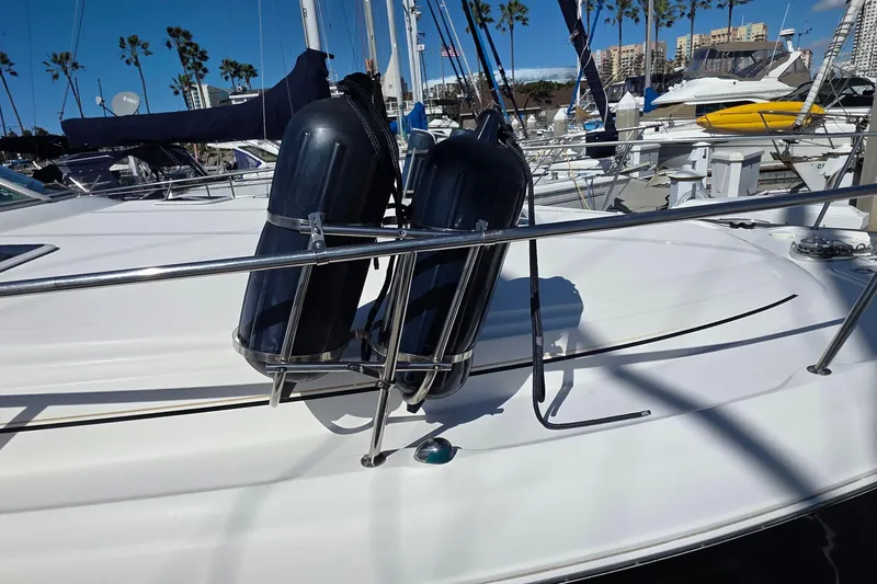 Slide: The Image of 2002 Sea Ray 340 Sundancer with fenders docked at marina, palm trees in background. - 33