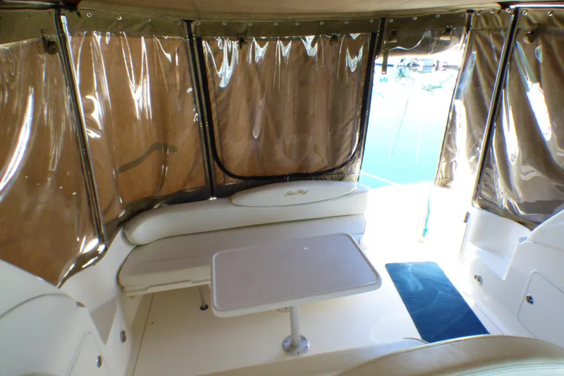 Slide: The Image of 2002 Sea Ray 340 Sundancer interior with seating and table, enclosed by clear curtains. - 34