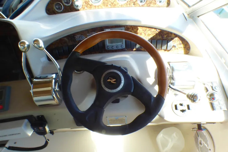 Slide: The Image of Steering wheel and controls of a 2002 Sea Ray 340 Sundancer boat cockpit. - 38