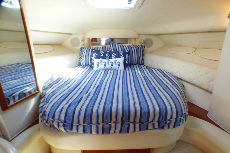 Slide: The Image of 2002 Sea Ray 340 Sundancer cabin with striped bedding and seahorse pillow. - 8