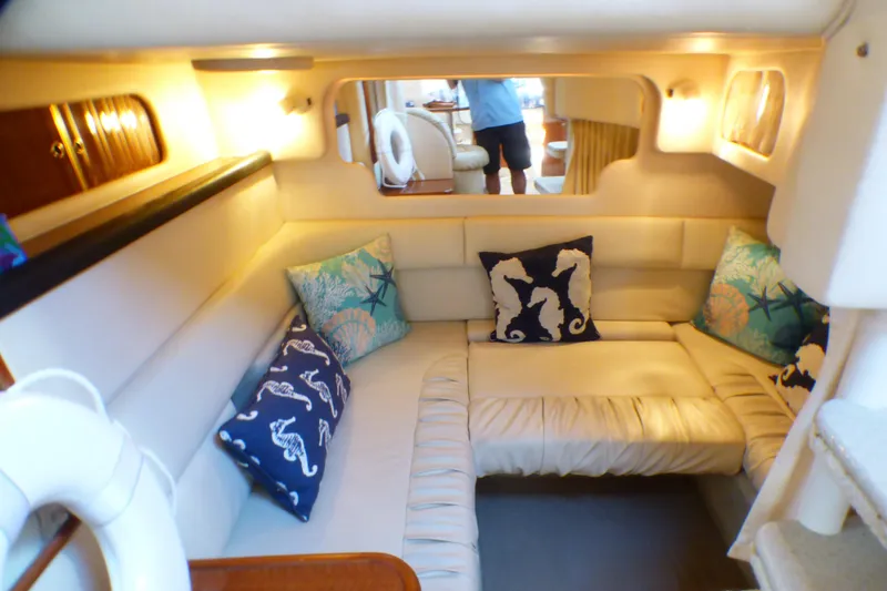 Slide: The Image of Interior of 2002 Sea Ray 340 Sundancer with cozy seating and decorative pillows. - 9