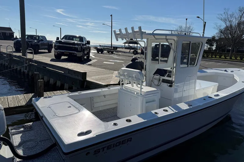 Slide: The Image of 2026 Steiger Craft 255 Chatham boat docked at marina with trucks nearby. - 3