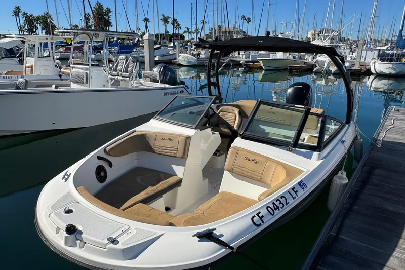 Slide: The Image of 2022 Sea Ray SPX 190 Outboard boat docked in a marina, surrounded by other vessels. - 11