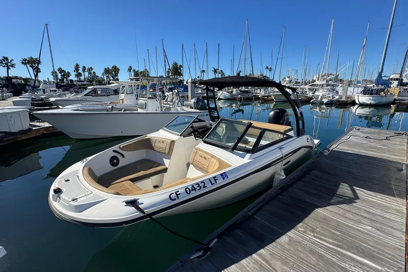Slide: The Image of 2022 Sea Ray SPX 190 Outboard boat docked at a marina with sailboats. - 12