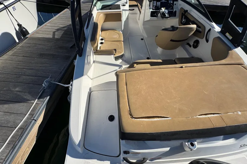 Slide: The Image of 2022 Sea Ray SPX 190 Outboard boat interior with tan seating, docked at marina. - 17