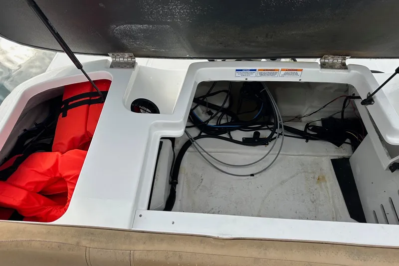 Slide: The Image of Open storage compartment of 2022 Sea Ray SPX 190 Outboard with life jackets and wiring. - 21