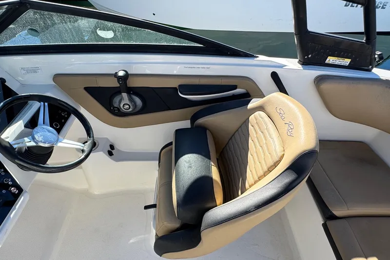 Slide: The Image of 2022 Sea Ray SPX 190 Outboard interior with steering wheel and tan seating. - 25