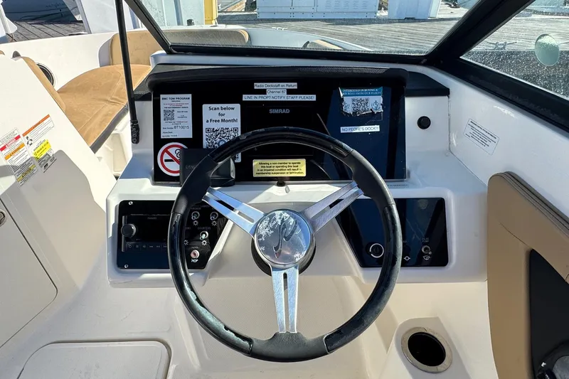 Slide: The Image of 2022 Sea Ray SPX 190 Outboard dashboard with steering wheel and control panel. - 28