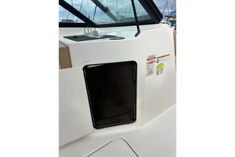 Slide: The Image of 2022 Sea Ray SPX 190 Outboard boat storage compartment with safety labels. - 33