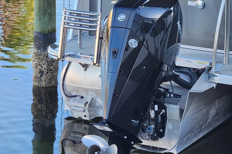 Slide: The Image of 2022 Tahoe Tritune 2585 ENT with powerful outboard motor at dockside. - 27