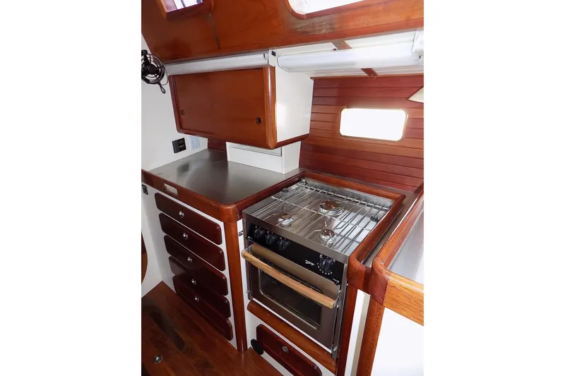 Slide: The Image of Compact kitchen in 2014 Custom Aluminum Expedition boat with wooden cabinets and stainless steel stove. - 31