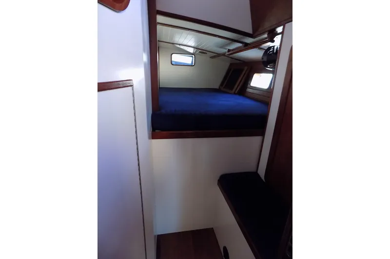 Slide: The Image of Interior of 2014 Custom Aluminum Expedition boat with blue bedding and wooden accents. - 41