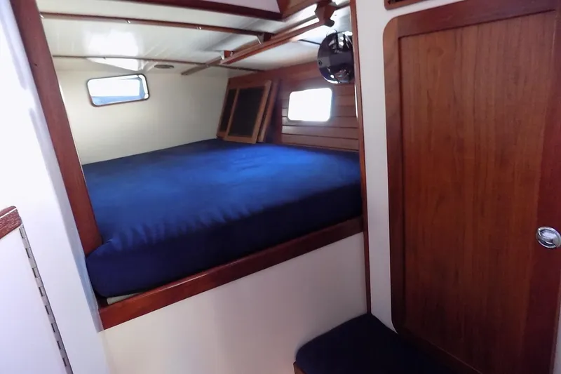 Slide: The Image of Cozy cabin interior of 2014 Custom Aluminum Expedition boat with wooden accents and blue bedding. - 42