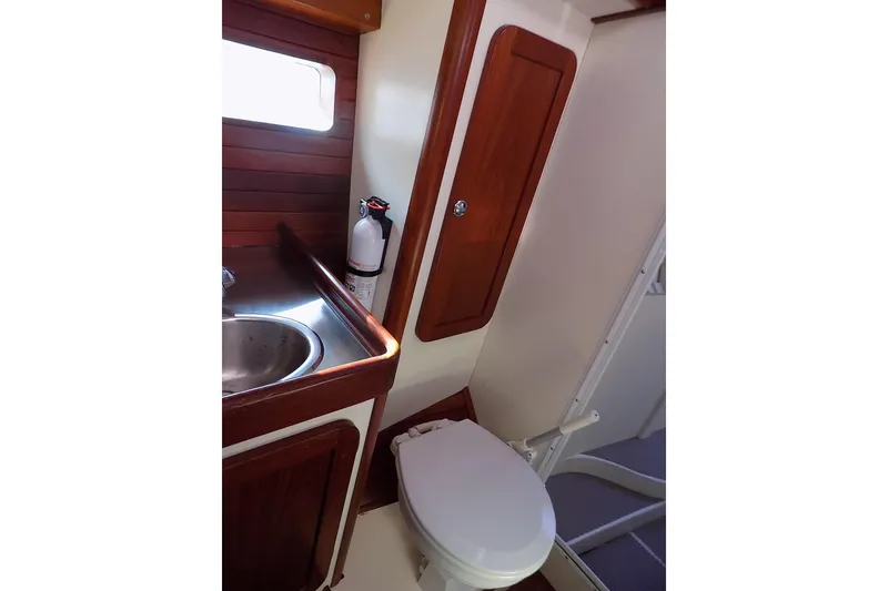 Slide: The Image of Compact bathroom in 2014 Custom Aluminum Expedition boat with wooden accents and stainless steel sink. - 64