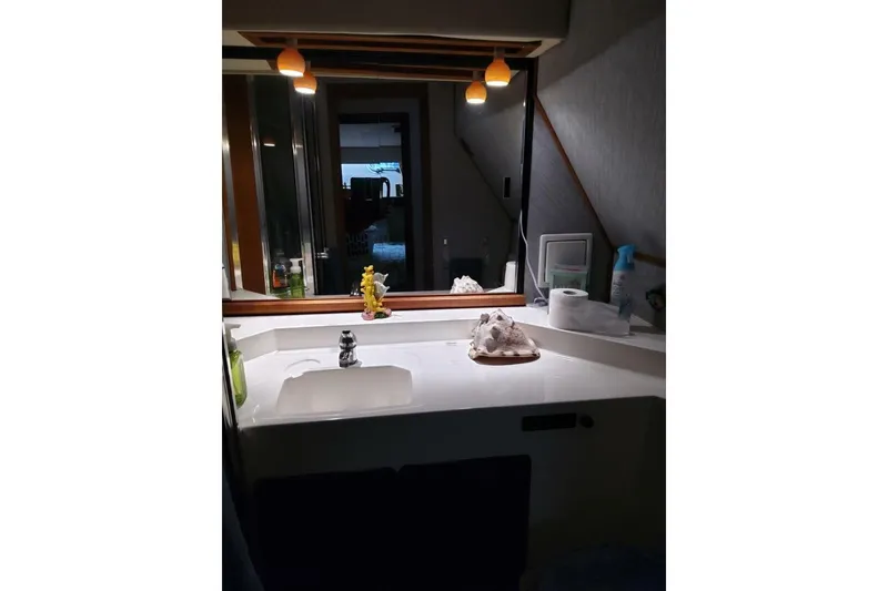Slide: The Image of Bathroom vanity in 1991 Bayliner 4588 Pilothouse yacht, featuring sink and mirror. - 19