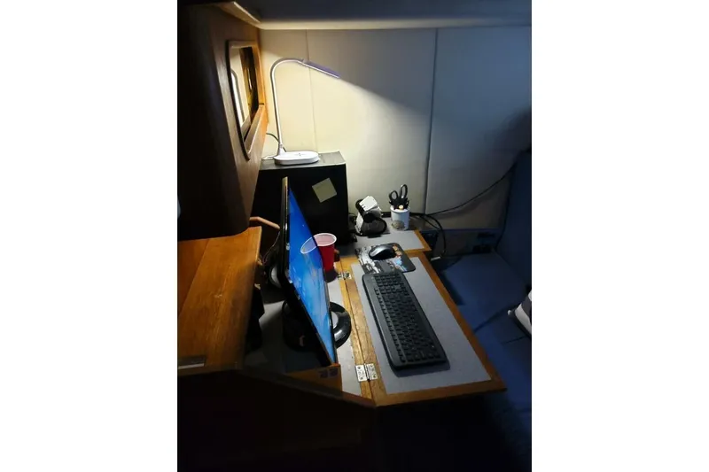 Slide: The Image of 1991 Bayliner 4588 Pilothouse interior with computer setup and desk lamp. - 21