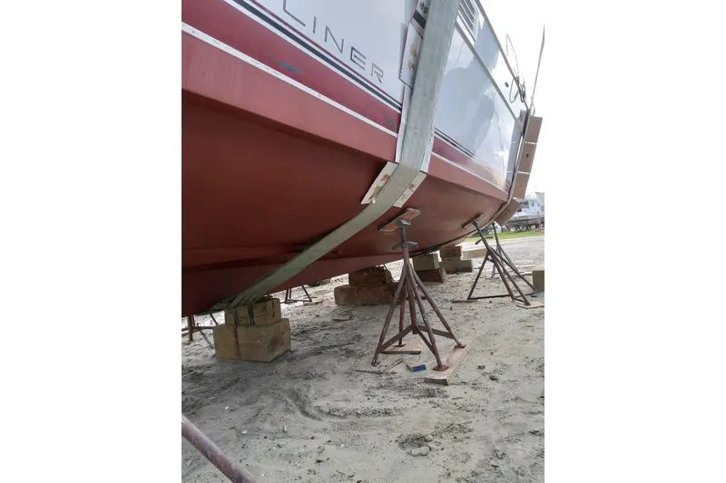 Slide: The Image of 1991 Bayliner 4588 Pilothouse on stands for maintenance, showing hull and supports. - 27