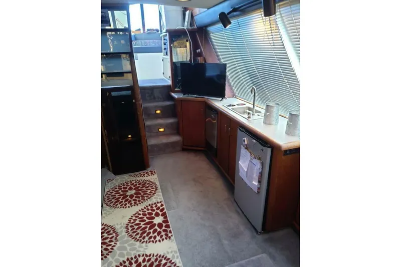 Slide: The Image of Interior of 1991 Bayliner 4588 Pilothouse with kitchenette, TV, and carpeted stairs. - 5