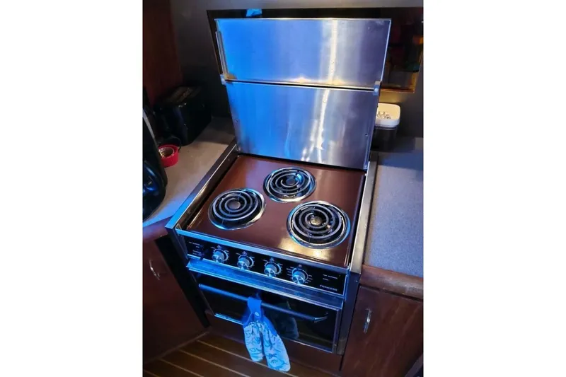 Slide: The Image of Stove in 1991 Bayliner 4588 Pilothouse yacht kitchen, featuring three burners and oven. - 6