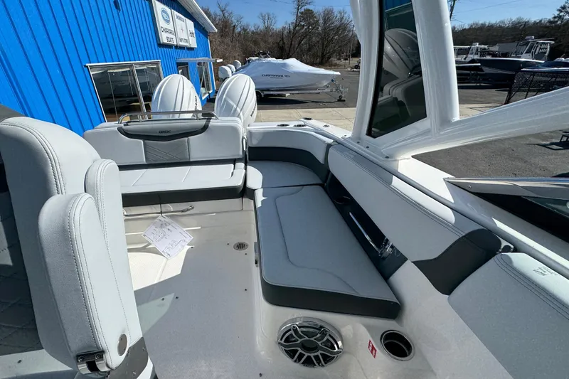 Slide: The Image of 2026 Chaparral 280 OSX boat interior with sleek seating and modern design at a dealership. - 12