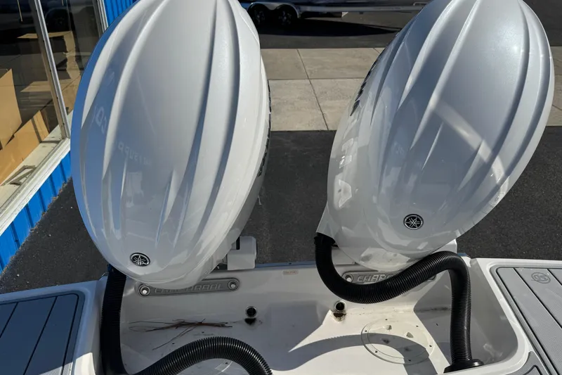 Slide: The Image of Twin outboard engines on a 2026 Chaparral 280 OSX boat, docked outdoors. - 23