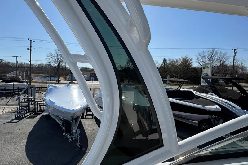 Slide: The Image of 2026 Chaparral 280 OSX boat on display at a dealership under clear blue skies. - 32