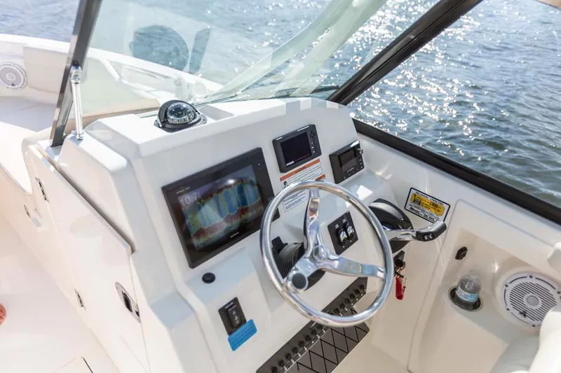 Slide: The Image of Manufacturer Provided Image: 2025 Cobia 240 Dual Console boat dashboard with steering wheel and navigation screens. - 10