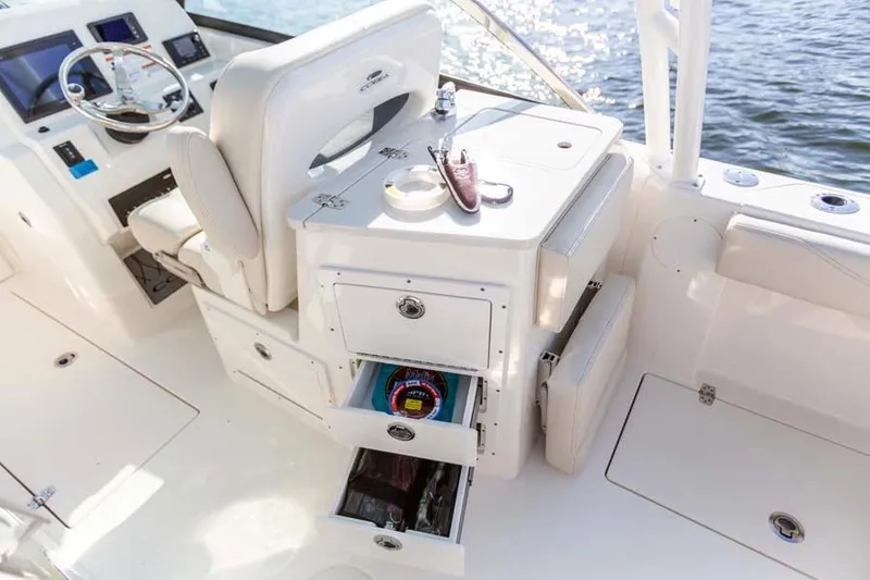 Slide: The Image of Manufacturer Provided Image: 2025 Cobia 240 Dual Console boat interior with storage drawers and helm. - 12