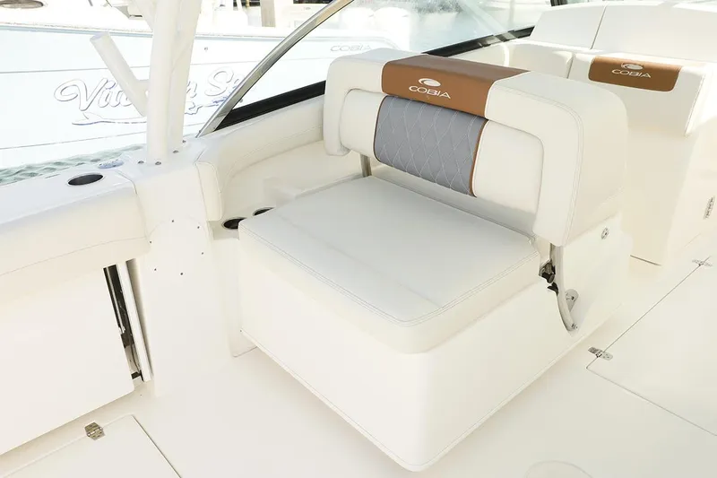 Slide: The Image of Manufacturer Provided Image: 2025 Cobia 280 Dual Console boat interior with white seating and brown accents. - 11