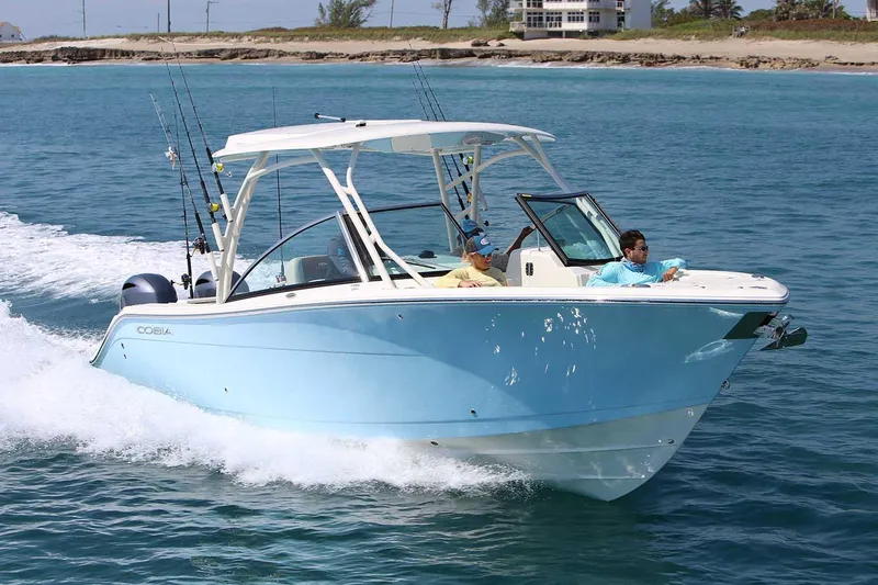Slide: The Image of Manufacturer Provided Image: 2025 Cobia 280 Dual Console boat cruising on clear blue water. - 2