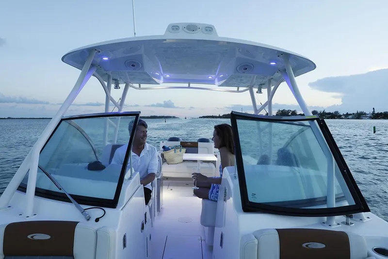 Slide: The Image of Manufacturer Provided Image: 2025 Cobia 280 Dual Console boat on water at sunset, featuring open cockpit and passengers. - 6