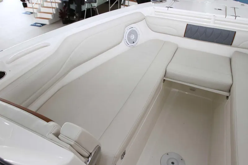 Slide: The Image of Manufacturer Provided Image: 2025 Cobia 280 Dual Console boat interior with white cushioned seating and speaker. - 7