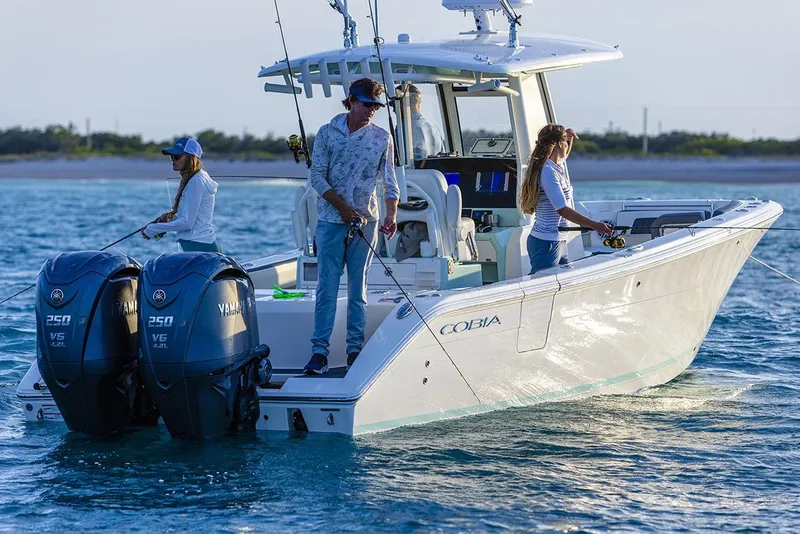 Slide: The Image of Manufacturer Provided Image: 2025 Cobia 265 Center Console boat with Yamaha engines, people fishing on calm water. - 2