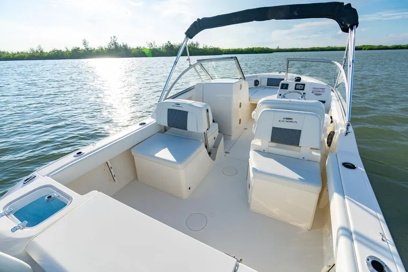 Slide: The Image of Manufacturer Provided Image: 2025 Cobia 220 Dual Console boat on calm water, sunny day. - 13
