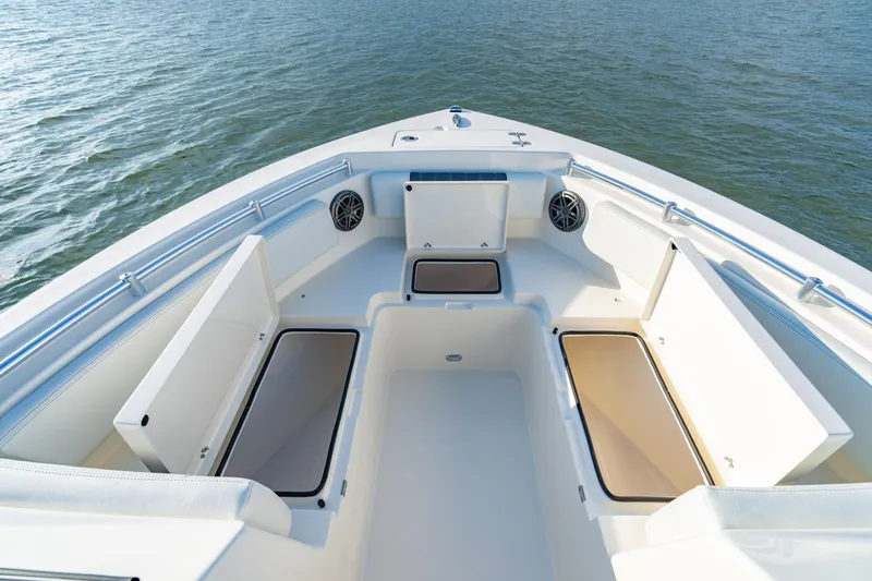 Slide: The Image of Manufacturer Provided Image: 2025 Cobia 220 Dual Console boat interior with open storage compartments on calm water. - 6