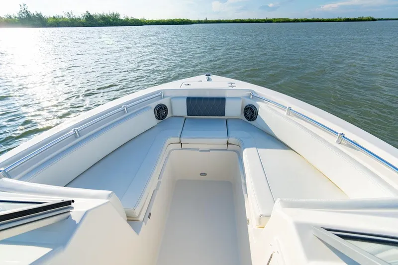 Slide: The Image of Manufacturer Provided Image: 2025 Cobia 220 Dual Console boat on calm water, featuring spacious seating. - 7