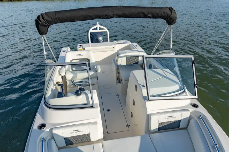 Slide: The Image of Manufacturer Provided Image: 2025 Cobia 220 Dual Console boat on water, featuring open seating and sleek design. - 8