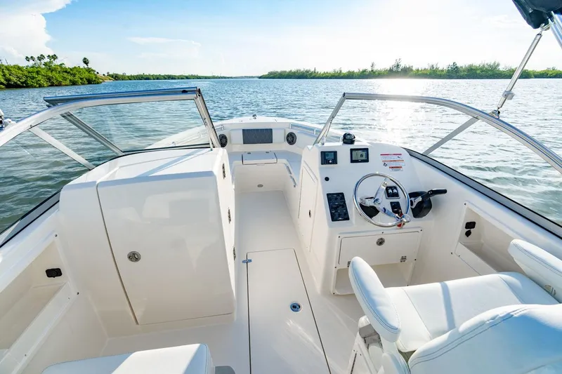 Slide: The Image of Manufacturer Provided Image: 2025 Cobia 220 Dual Console boat interior on a sunny day, open water view. - 9