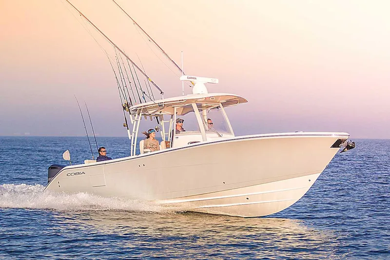 The Image of Manufacturer Provided Image: 2025 Cobia 320 Center Console boat cruising on open water at sunset. - 0