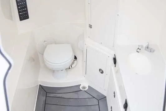 Slide: The Image of Manufacturer Provided Image: 2025 Cobia 320 Center Console boat bathroom with toilet and sink. - 17