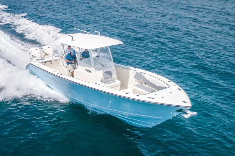 Slide: The Image of Manufacturer Provided Image: 2025 Cobia 320 Center Console boat cruising on open water. - 2
